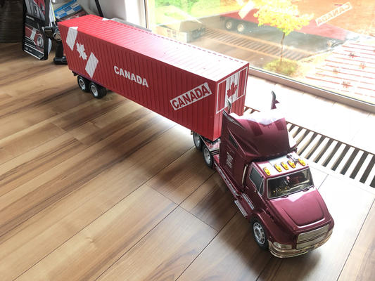 カナダ輸入住宅の資材を載せたコンテナを運ぶトレーラー